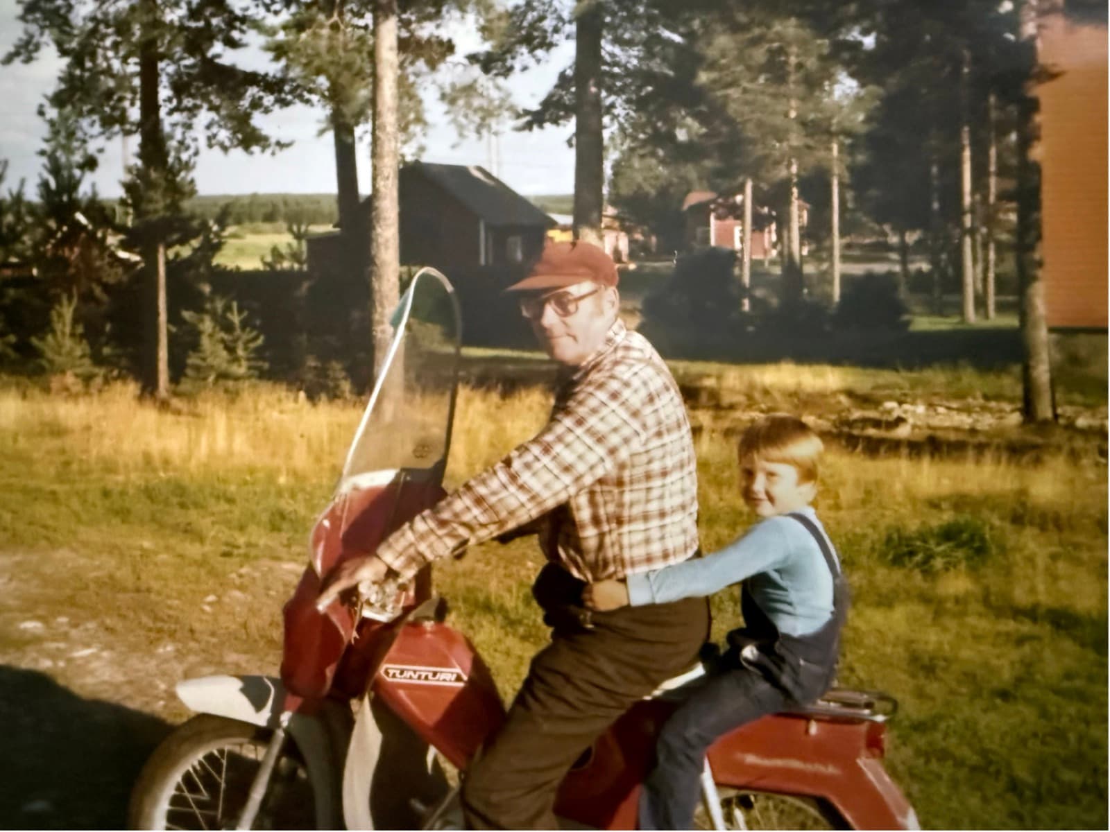 Mies ja lapsi vanhalla mopolla